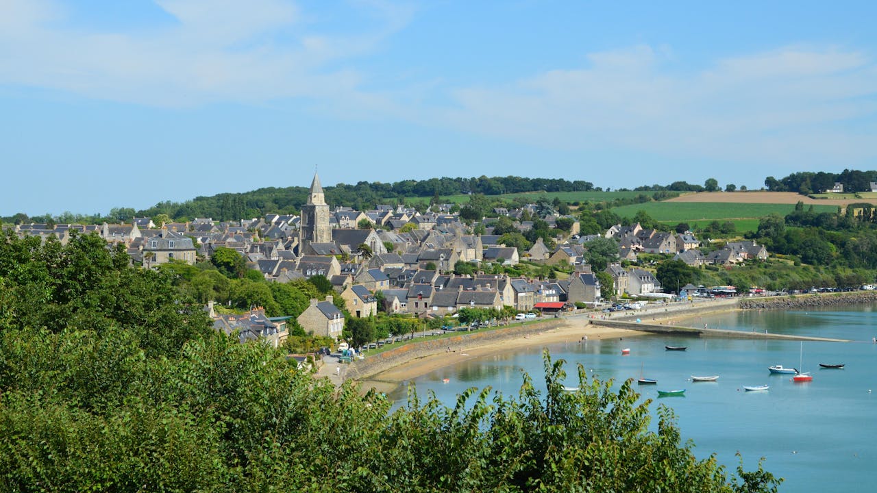 Charming coastal village landscape of Saint-Suliac in Brittany, France, with serene waterfront and greenery.